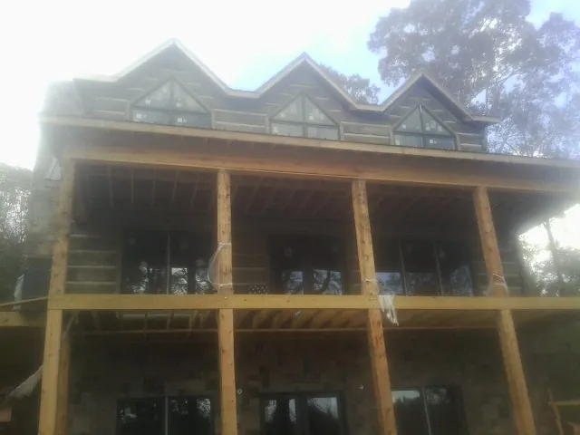 Dormers and porch framing on a large log home under construction — Roof Coating work by our crew in Blairsville